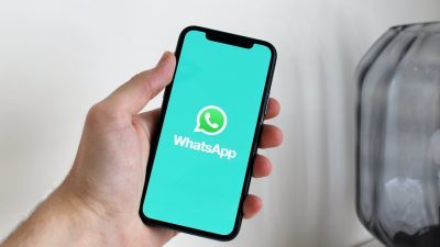 a person holding a cellphone with logo on the screen